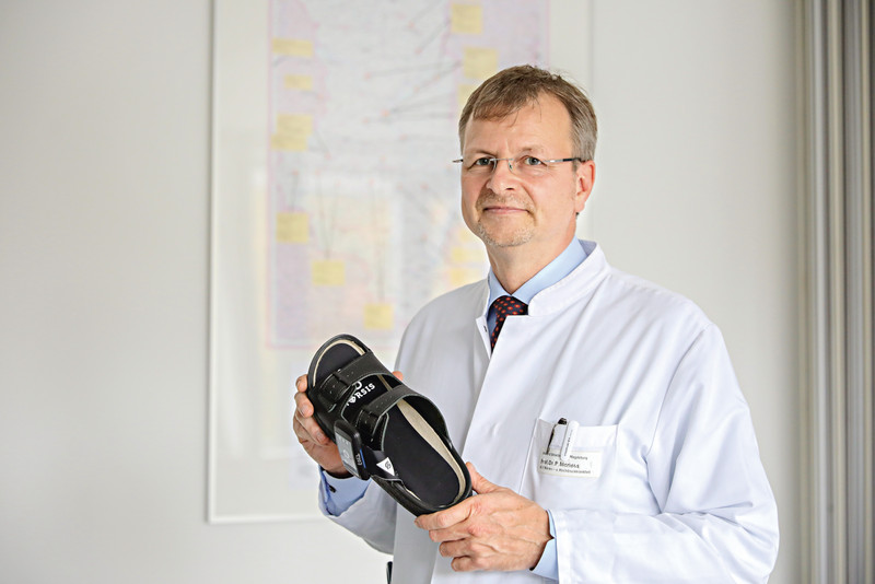 Das Bild zeigt Prof. Dr. Peter R. Mertens mit der intelligenten Einlegesohle in der Hand.