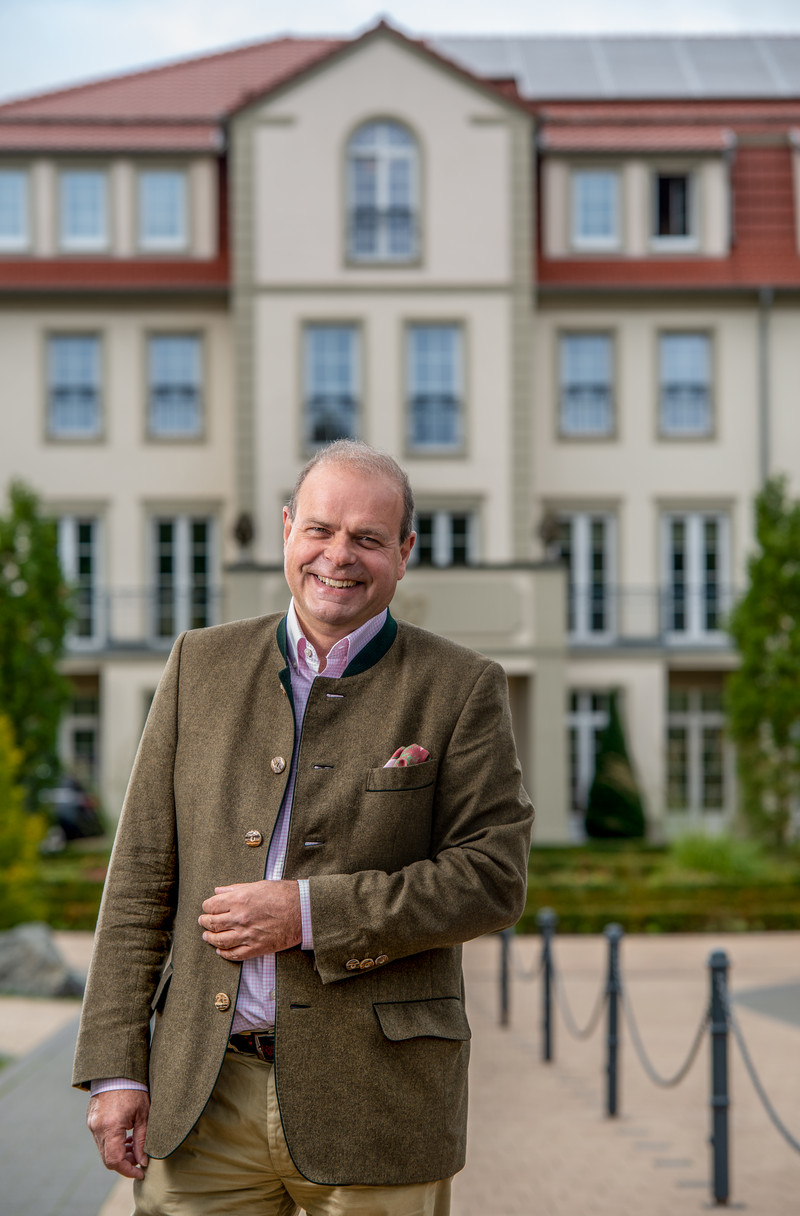 Das Bild zeigt Dr. Clemens Ritter von Kempski vor seinem Hotel Naturresort Schindelbruch.