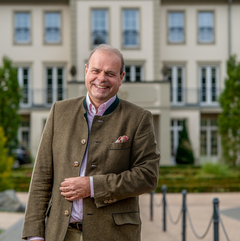 Das Bild zeigt Dr. Clemens Ritter von Kempski vor seinem Hotel Naturresort Schindelbruch.
