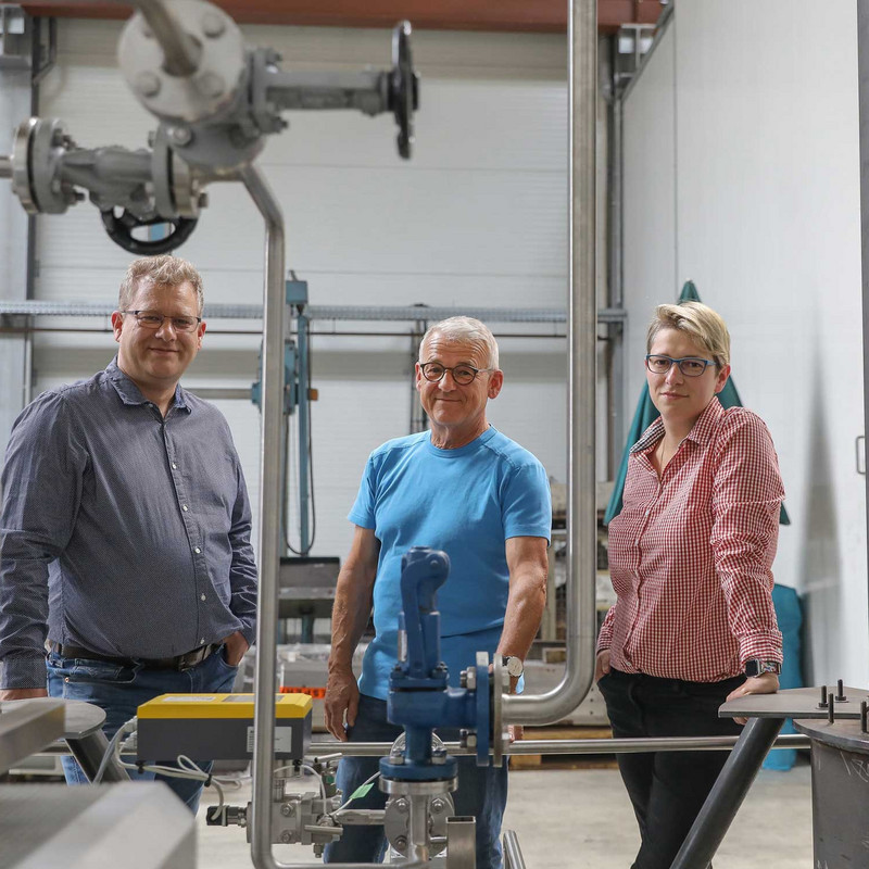 Das Bild zeigt Tino, Joachim und Kristina Lerche bei dem Prototypen des Solarkraftwerks im Jerichower Land.